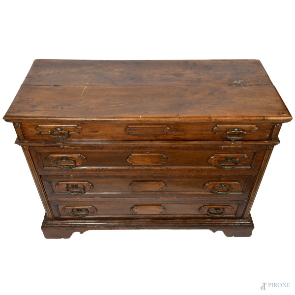 Cassettone in noce con fronte scandito da tre cassetti e finto cassetto. Piano superiore apribile...