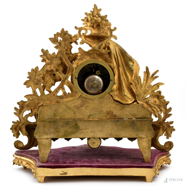 Orologio in antimonio dorato con quadrante a smalto e numeri romani. Sculture apicali di dama con...