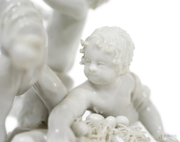 Gruppo in porcellana bianca con finiture dorate raffigurante tre putti che raccolgono le uova, ve...