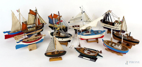 Lotto di dodici modellini di imbarcazioni, in legno dipinto ed altri materiali, altezza max cm 18, XX secolo, (difetti e mancanze).
