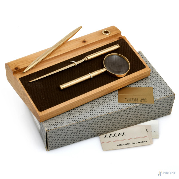 Set da scrivania Lalex composto da supporto, tagliacarte, lente e penna placcati in oro 22 kt, XX secolo, misura massima cm 4x21x12, (penna da revisionare, segni di usura)