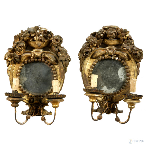 Coppia di specchierine in legno intagliato e dorato con applique a due luci, XIX-XX secolo, cm 42x25x12,5, (segni di usura, difetti, cadute di doratura, rotture, mancanze, restauri, fori di tarlo, da revisionare)