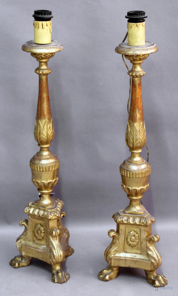 Coppia di portaceri in legno intagliato e dorato, poggianti su tre gambe leonine, montati a luce elettrica, altezza 79 cm, XIX secolo.
