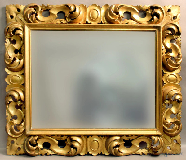 Specchiera in legno dorato ed intagliato a motivi di foglie d&#39;acanto, inizi XX sec., misure massime 67 x 57 cm.