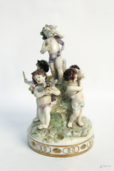 Allegoria di putti musicanti, gruppo in porcellana policroma, marcata, (difetti), h. 25 cm.