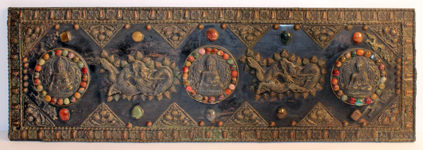 Pannello tibetano in rame sbalzato a soggetto di Budda con draghi, finiture con pietre dure, fine XIX sec, h. 29x91 cm