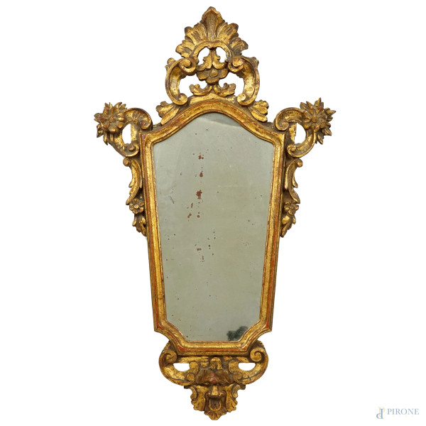 Specchiera di linea sagomata in legno dorato e scolpito a motivi floreali, ingombro totale cm 74x44, fine XIX-inizi XX secolo, (difetti e restauri).