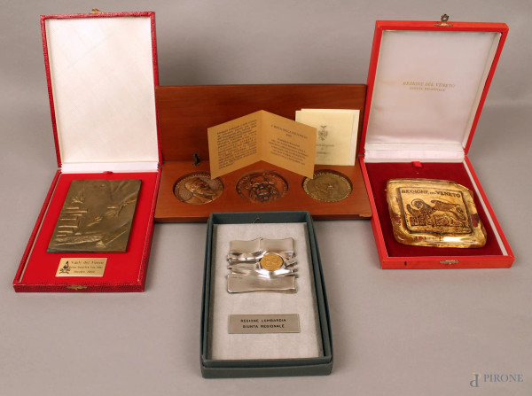 Lotto composto da quattro placche commemorative in materiali diversi, entro astucci.