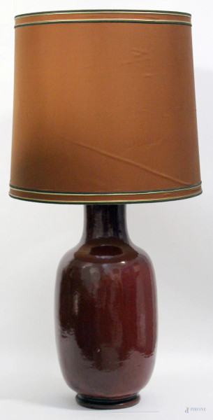 Lampada in maiolica in smalto rosso, completo di paralume, h. 61 cm.
