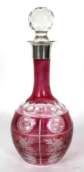 Bottiglia in cristallo di Boemia, corpo intagliato e molato color rosso rubino, finale in argento, altezza cm. 30.