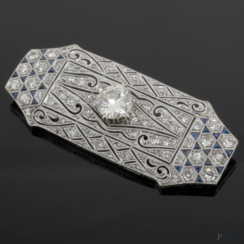 Spilla ottagonale in oro bianco finemente lavorato con pavè brillanti e zaffiri e diamantre centrale taglio brillante (mm 7,3), gr. 8,6  - Asta ASTA A TEMPO | IN ARTE VERITAS - Aste Pirone
