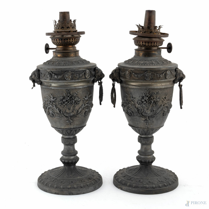 Coppia di lampade ad olio in antimonio a guisa di urna con rilievi di teste leonine e candelabre, XX secolo, altezza cm 34, (segni di usura, difetti, mancanze, da revisionare)  - Asta  ASTA A TEMPO | VARIÆ - Aste Pirone