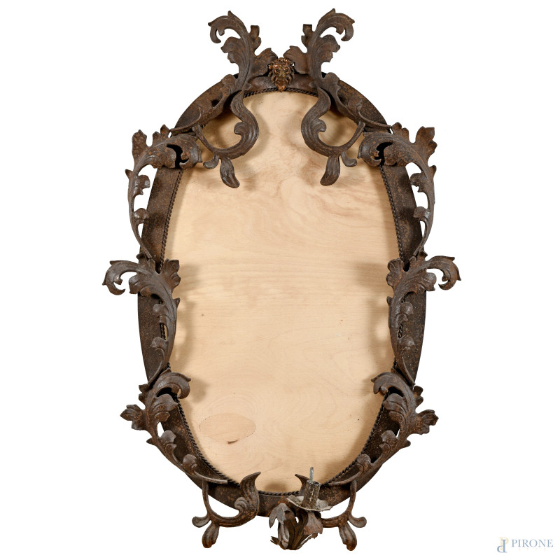 Specchiera a serto ovale in ferro battuto a decori vegetali, XX secolo, ingombro cm 94x64x25 circa, (segni di usura, difetti)  - Asta RAPIDA SOLIS - Aste Pirone